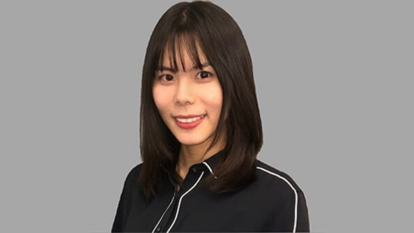 Xinyi chen smiles in front of gray background.