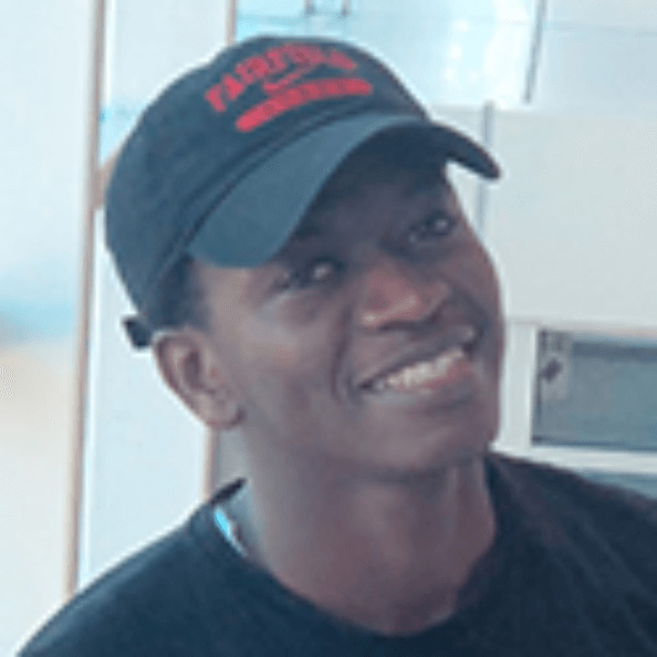 Mahfouz Soumare smiles in a Fairfield baseball cap and black shirt.