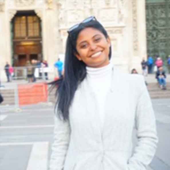 Jessica Castillo smiles in front of a building.