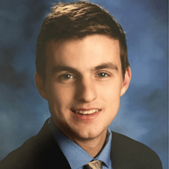 Kevin Parsons smiles in front of blue background.