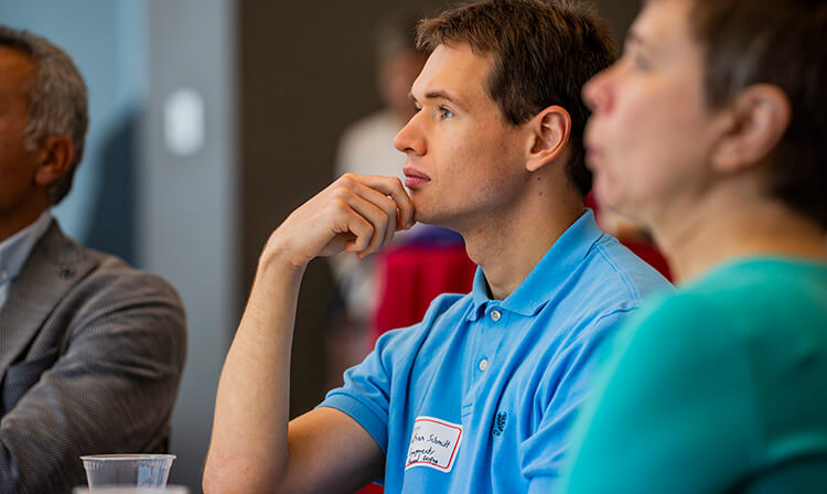 Audience members listen to a speaker.