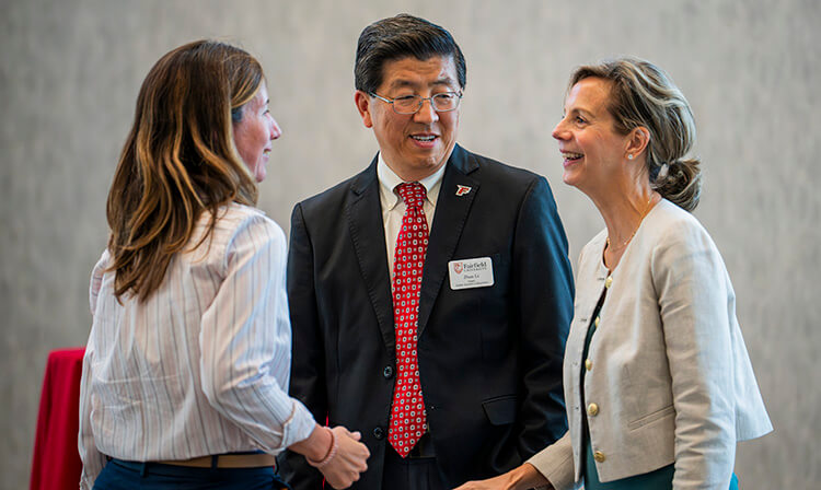 Three professionals engage in conversation.