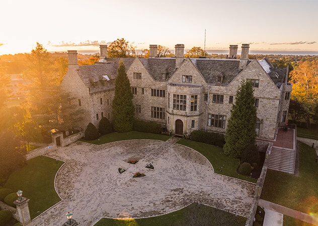 Overhead perspective of Bellarmine Hall nestled among trees and manicured lawns, highlighting its elegance and surroundings.