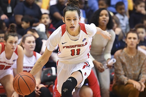 A basketball player in a jersey that reads “Fairfield 11” dribbles a basketball.