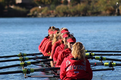 A crew boat of 8 people on the water.