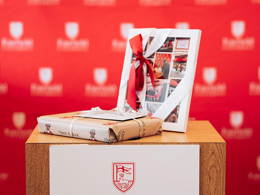 Fairfield University memory images encased in a frame with a wrapped present on a wooden podium.