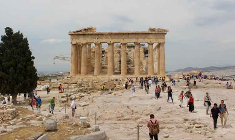 People walking to and from a large building with columns.