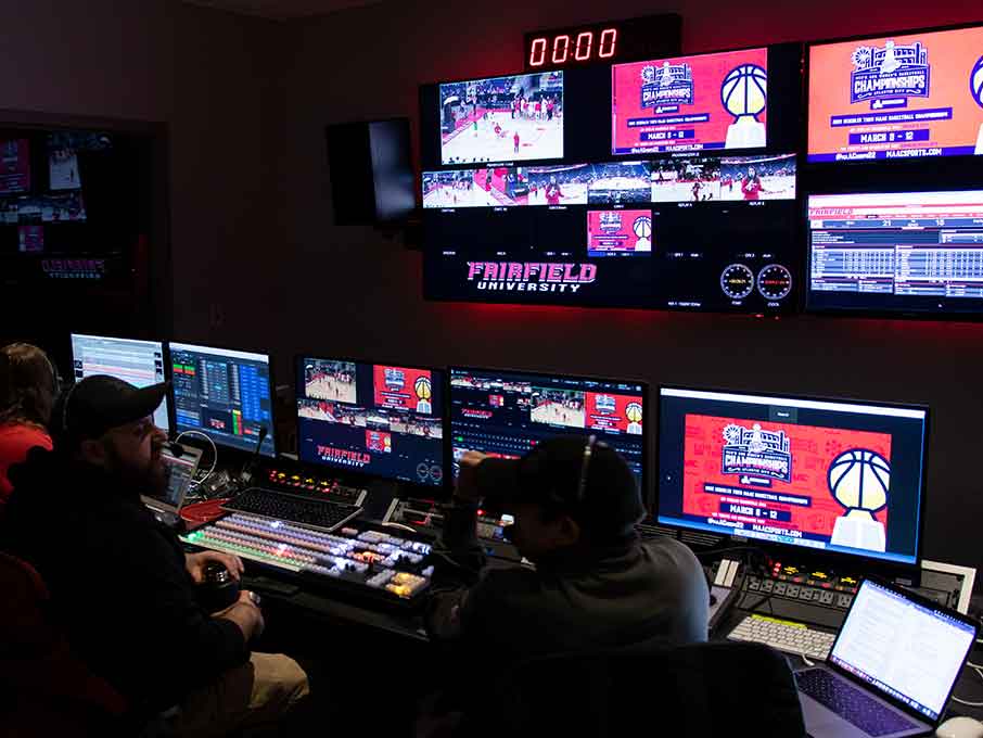 Students sit in a broadcast control room preparing for a game.