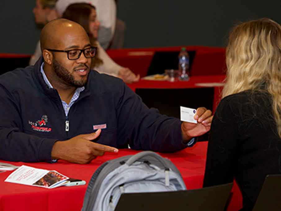 A man and a woman engaged in conversation while sitting at a table together.