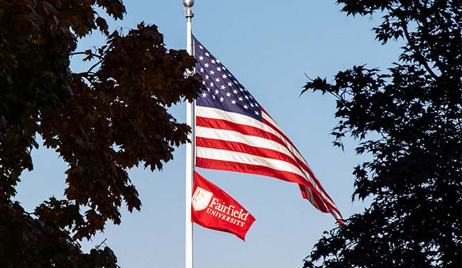 American flag waving in the wind with Fairfield flag underneath it. 