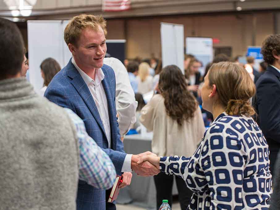 Two people in professional clothing shake hands.