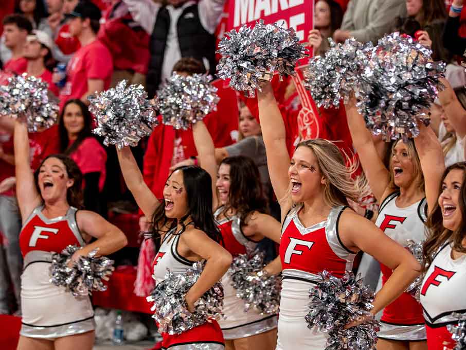 Cheerleaders cheering at a basketball game.