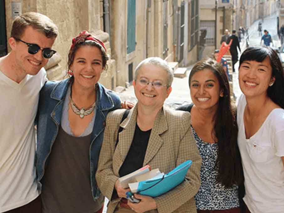 Students posing for photo with street in background.