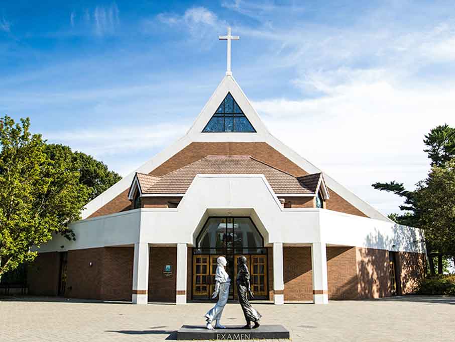 Exterior photo of front of Egan Chapel with blue sky.