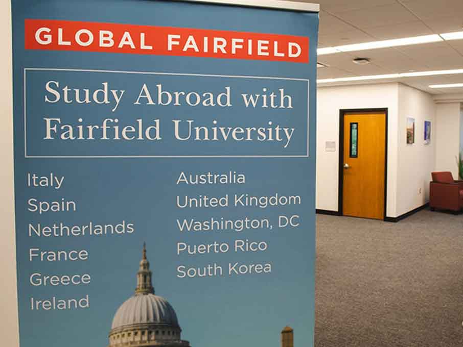 A poster reads “Global Fairfield: Study Abroad with Fairfield University” and lists the following locations: Italy, Spain, Netherlands, France, Greece, Ireland, Australia, United Kingdom, Washington, DC, Puerto Rico, and South Korea.