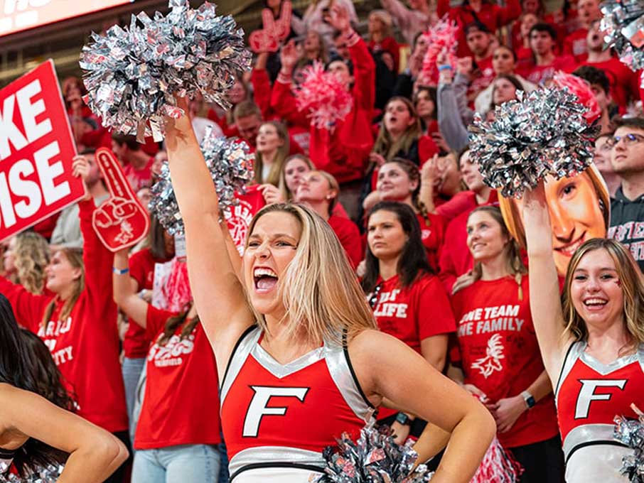 Cheerleaders and fans at a basketball game.