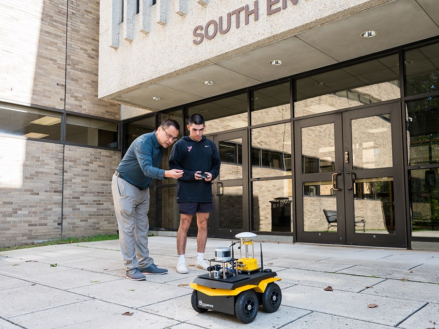 Dr. Paheding and student training Jackal, the Unmanned Ground Vehicle.