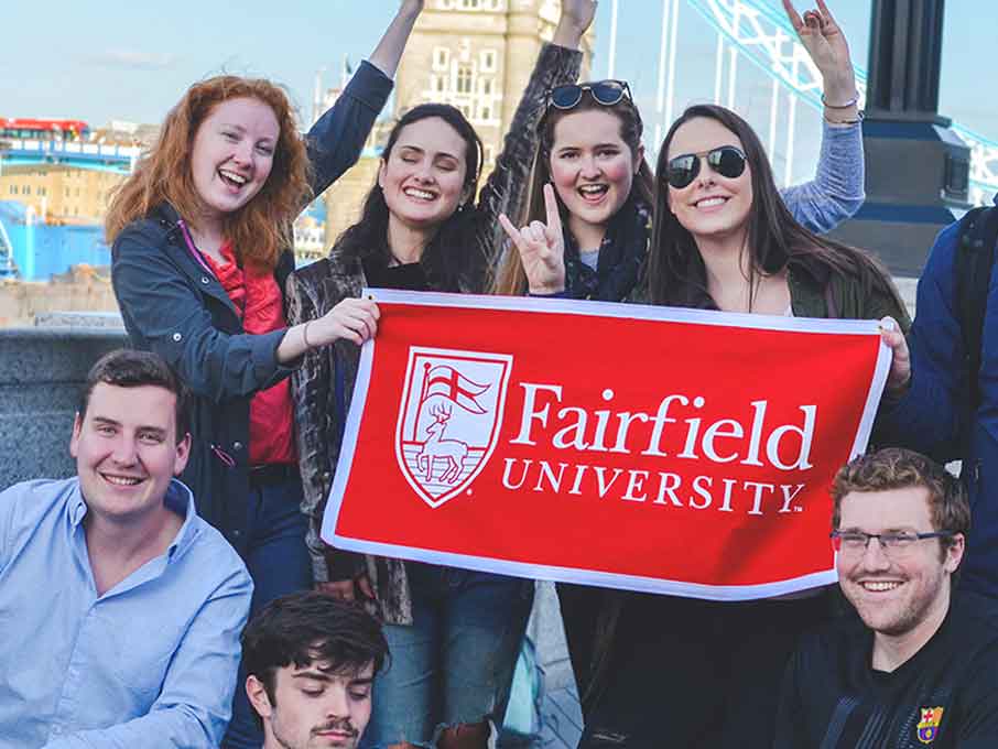 Study abroad students pose with a fairfield university banner.