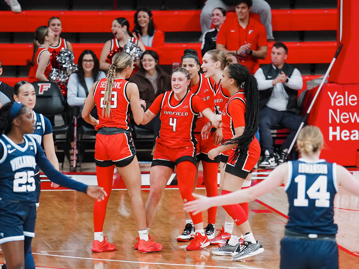 Celebrating on the court, Fairfield University's women's basketball team expresses joy and unity after a hard-fought victory.