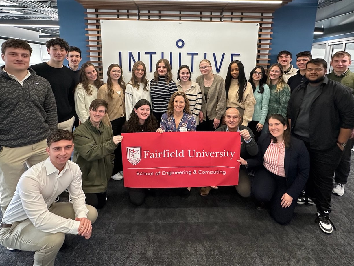 Fairfield students posing in front of the Inuititive Surgical lobby sign.