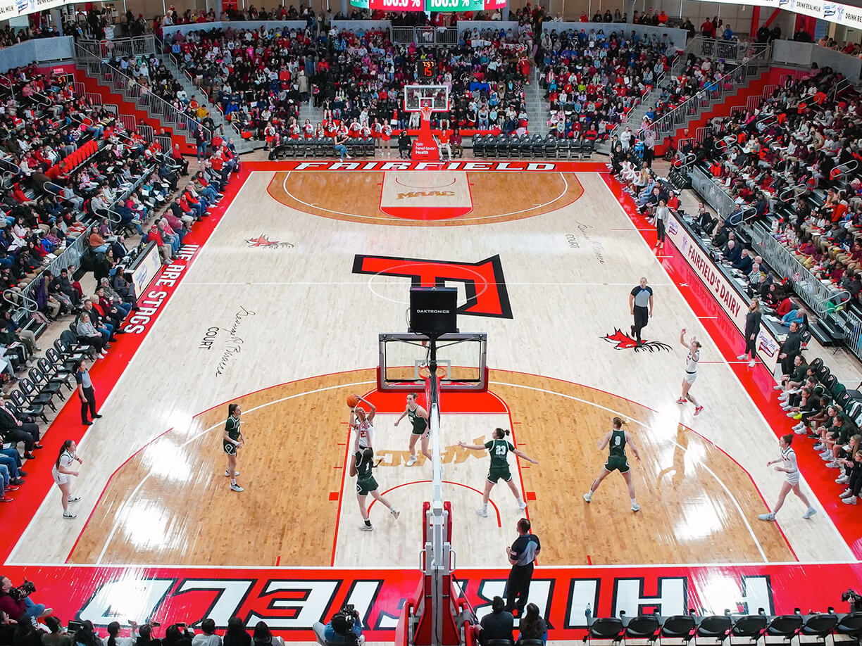 An exciting basketball match taking place in the Leo D. Mahoney Arena, showcasing players and a cheering crowd.