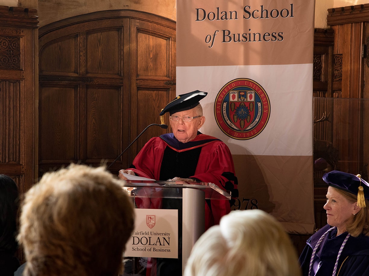 Charles Dolan standing at a podium, thanking the community for his honorary Doctor of Laws degree.