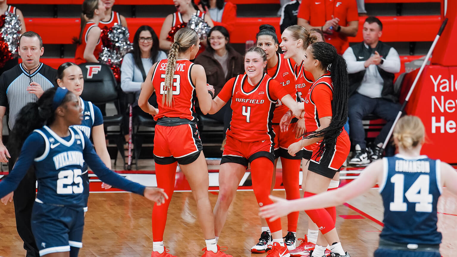 Celebrating on the court, Fairfield University's women's basketball team expresses joy and unity after a hard-fought victory.