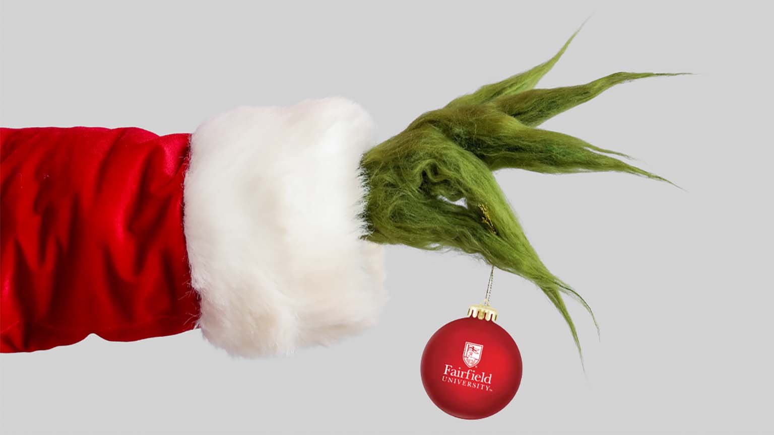 Image of the Grinch's hand holding a Christmas ornament