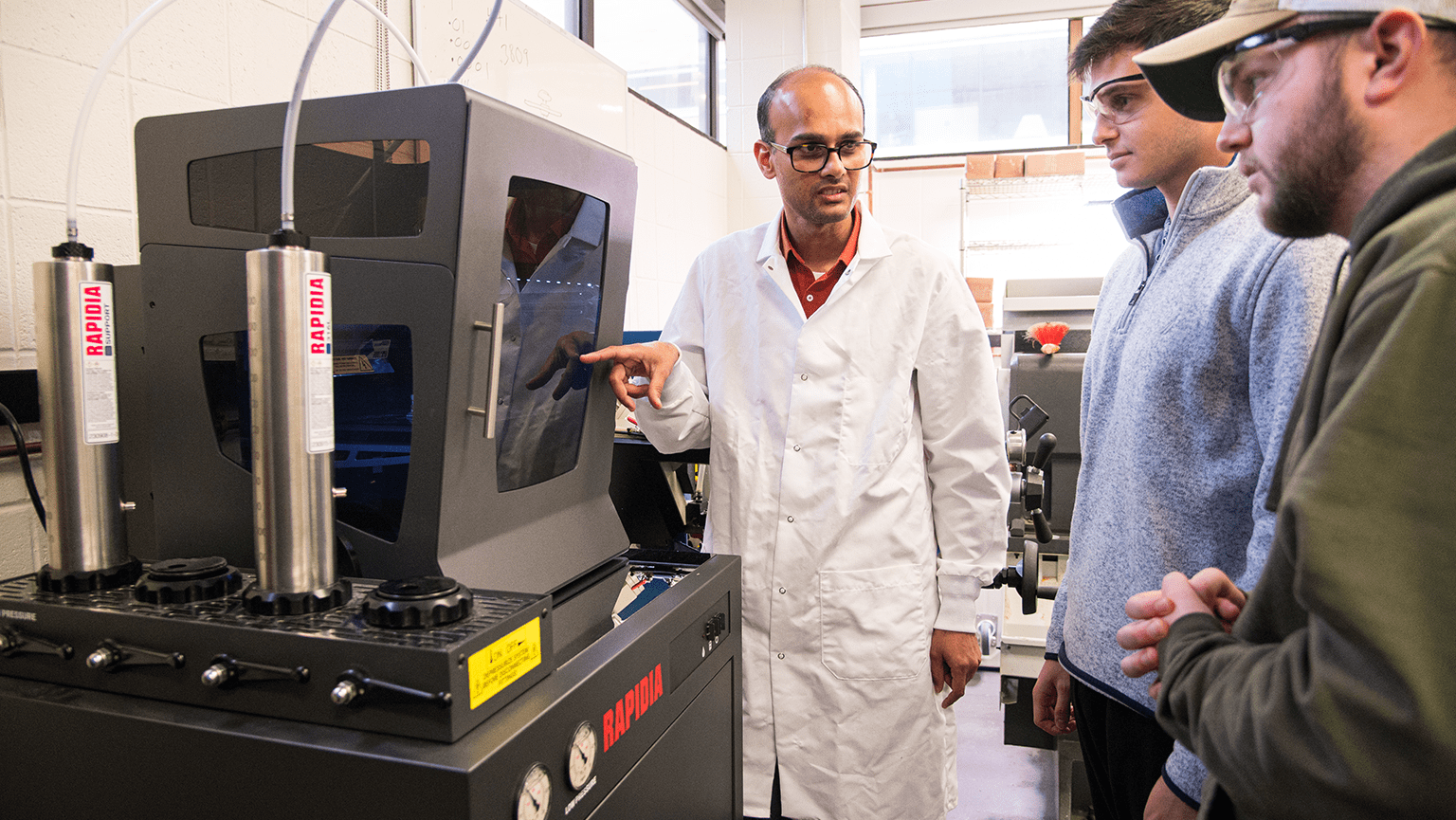 Engineering professor and students using the new 3D printer, Rapida Conflux.