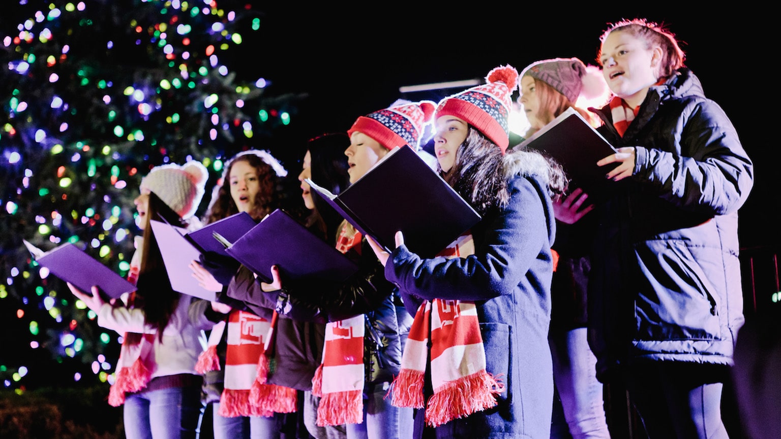 Fairfield students singing Christmas carols outside, near the campus holiday tree.