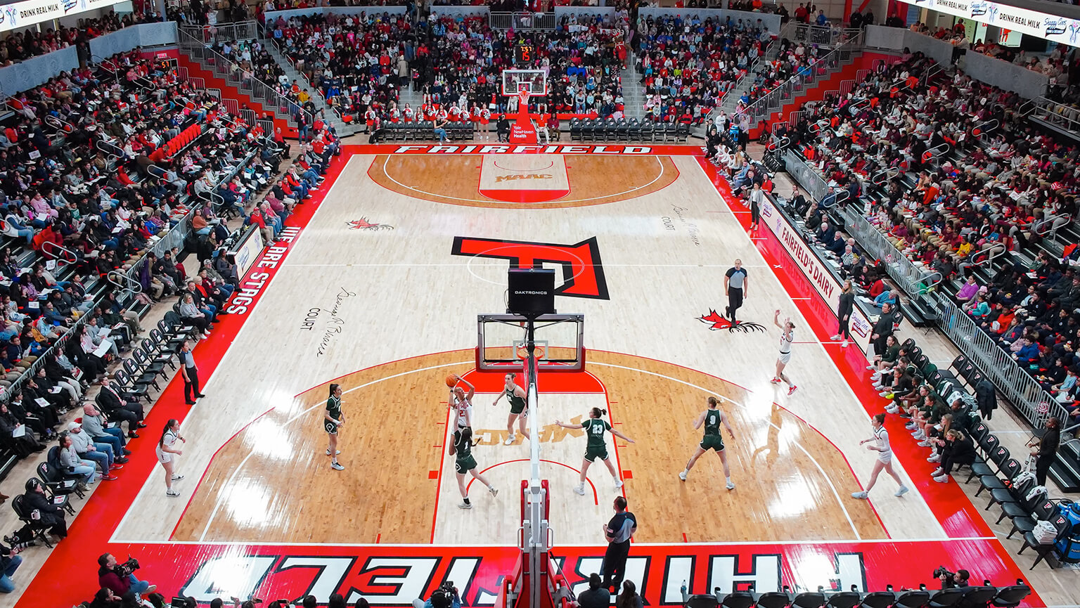 An exciting basketball match taking place in the Leo D. Mahoney Arena, showcasing players and a cheering crowd.