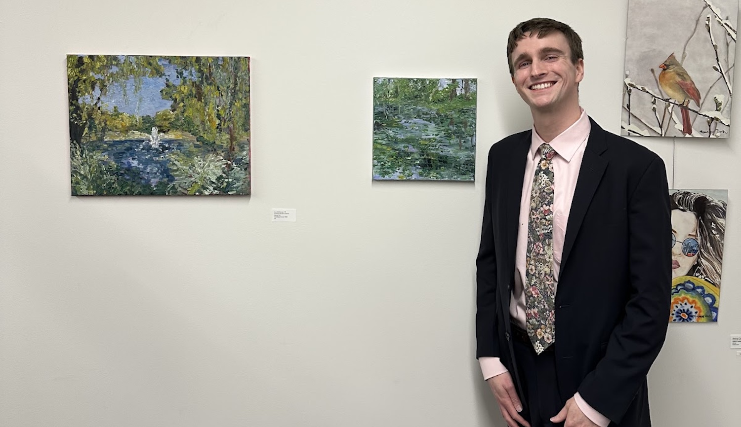 Student standing in front of artwork. 