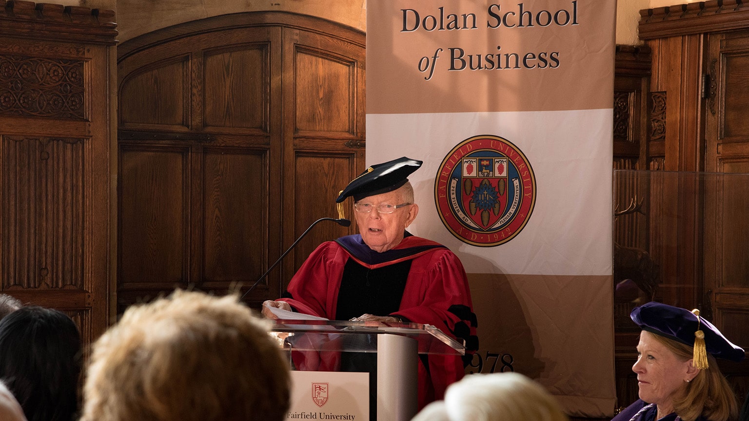 Charles Dolan standing at a podium, thanking the community for his honorary Doctor of Laws degree.