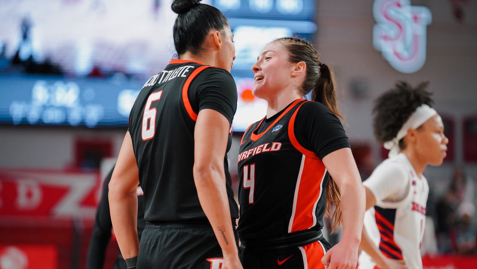 Women's Basketball players standing chest to chest as they hype one another up.