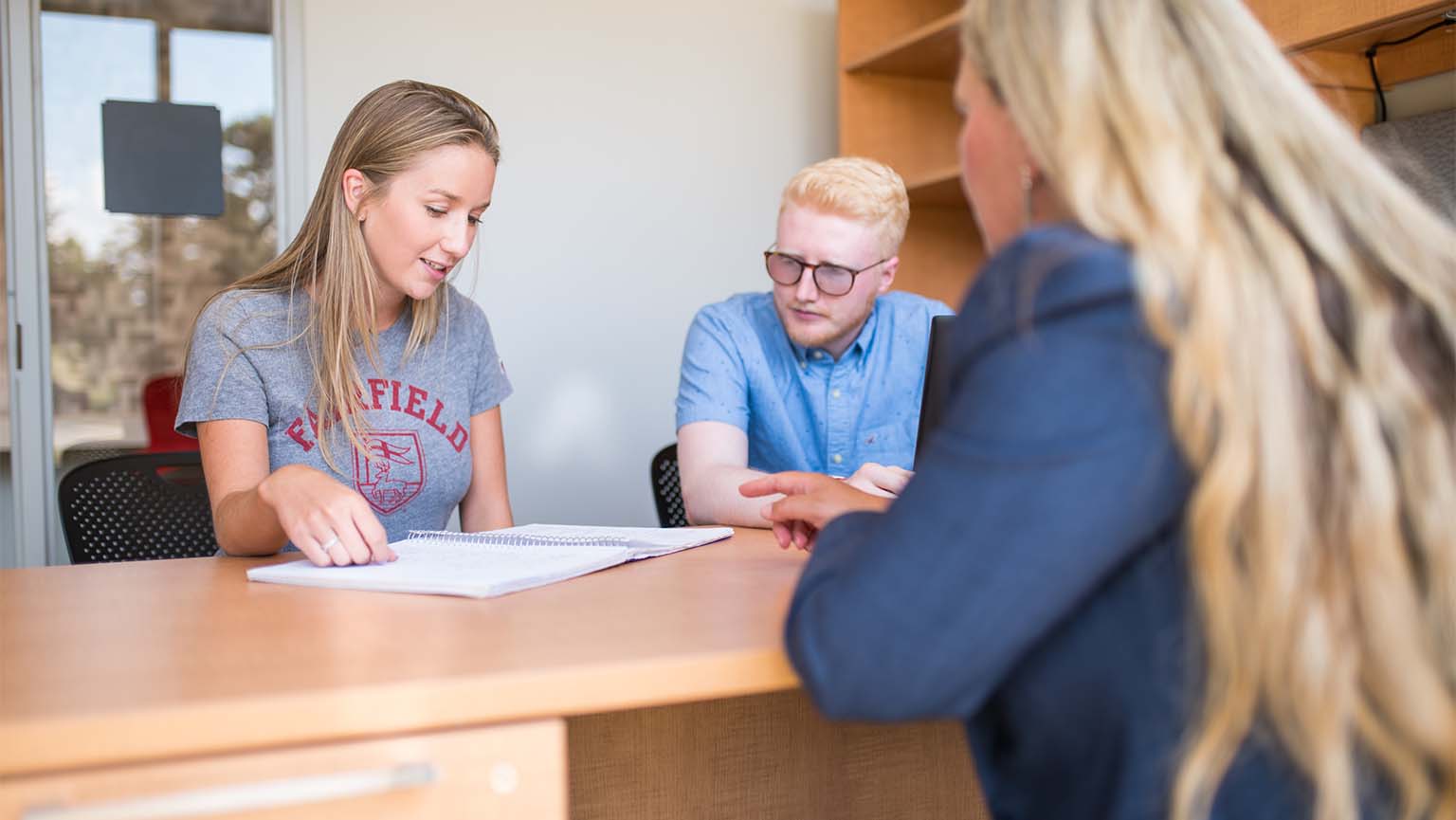 Image of students and professor sitting in office