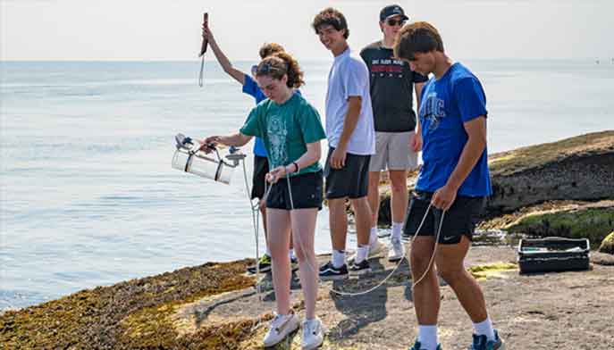 Fairfield University students collect samples to measure water quality.