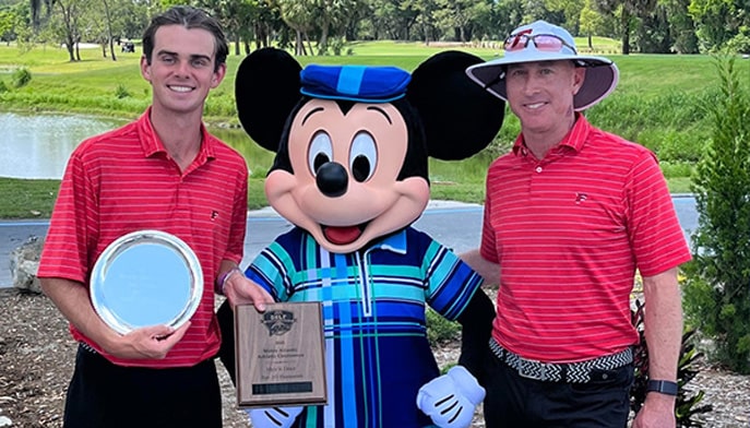 Killian McGinley holds the McLeod Trophy alongside Mickey Mouse and Director of Fairfield Golf Doug Holub