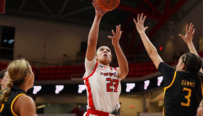 Fairfield University Stag Athlete Callie Cavanaugh '20 leaping to sink a basket in a home basketball game.