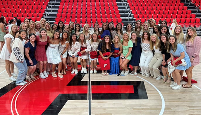 Group photo of student athletes at center court inside the Leo D. Mahoney Arena.