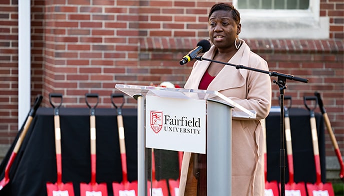 Nakia Létang speaking at a podium during a Fairfield University event.