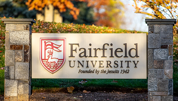 A Fairfield University sign displayed prominently on campus, showcasing the institution's name and emblem.