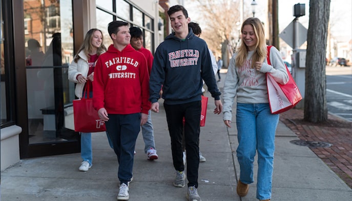 Students walking around downtown Fairfield wearing Fairfield University gear.