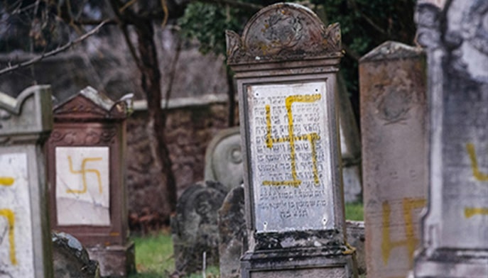 Gravestones graffitied with swastikas. 