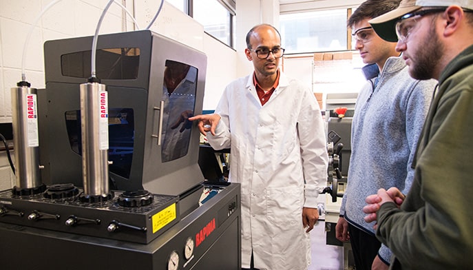 Engineering professor and students using the new 3D printer, Rapida Conflux.