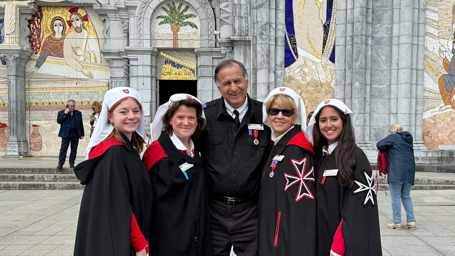 A group photo of Amanda Marino ‘25, Dr. Katherine Saracino, Joseph Berardino ‘72, Gail Berardino, and Samantha Flores ’25 outside the Basilique Notre Dame du Rosaire in Lourdes, France.