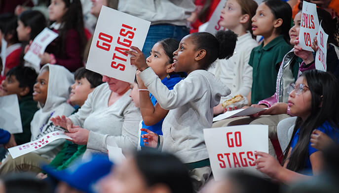 An exciting basketball match taking place in the Leo D. Mahoney Arena, showcasing players and a cheering crowd.