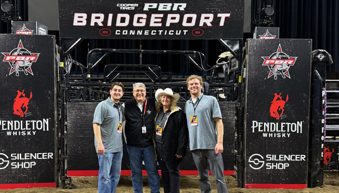 Four people stand before a "PBR Bridgeport, CT" sign, highlighting their visit to this notable location.