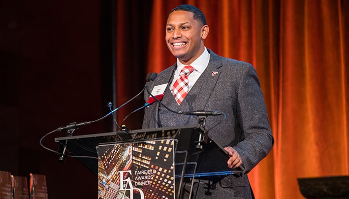 Emcee Chris Miles ’03 giving his Awards Dinner opening speech and remarks at a branded, on-stage podium.