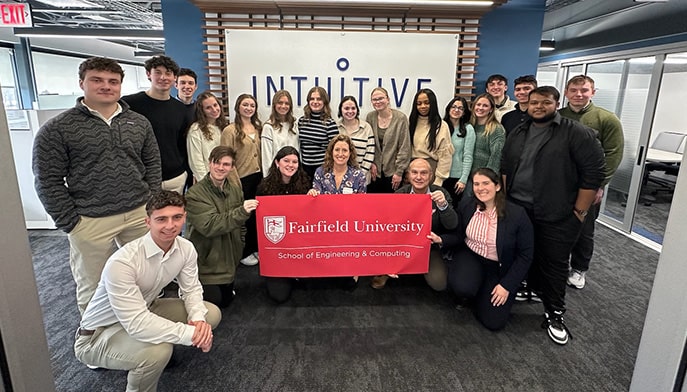 Fairfield students posing in front of the Inuititive Surgical lobby sign.