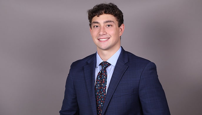 Peter Baron ’23, dressed in a blue suit, button down, and tie.